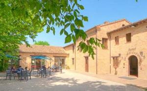 a group of people sitting at tables outside a building at Hotel La Foresteria in Abbadia di Fiastra