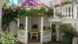 Una casa blanca con una mesa y flores. en Apartments Vodice Marica, en Vodice
