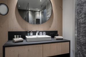 a bathroom with a sink and a mirror at Ski & Bike Hotel Wiesenegg in Saalbach-Hinterglemm +94 photos