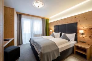 a hotel room with a large bed and a window at Ski & Bike Hotel Wiesenegg in Saalbach-Hinterglemm