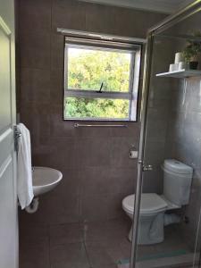 baño con lavabo y aseo y ventana en 24 on WRENCH, en Ciudad del Cabo