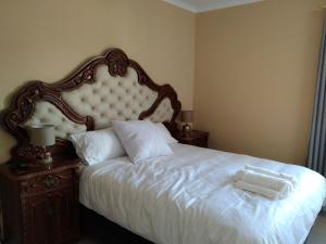 a bedroom with a white bed with a large headboard at 24 on WRENCH in Cape Town