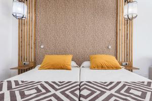 een bed met twee oranje kussens erop bij Cotillo Sunset in Cotillo