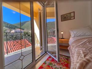 1 dormitorio con cama y vistas a un balcón en "Mykines" Apartment of Levidi Arcadian Apartments, en Levidhion