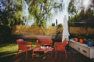 a patio with three chairs and a table and an umbrella at Villa Calipso in Mondello