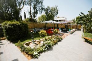 a garden with a table and chairs and an umbrella at Villa Calipso in Mondello