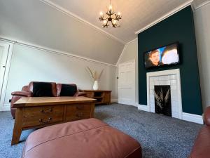 a living room with a couch and a fireplace at Ormes Hey Apartments in Llandudno