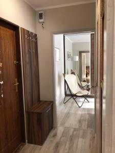 Apartament Datini, 40 m2 في كاليش: ممر به مرآة وكرسي في الغرفة