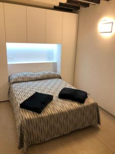 a bedroom with a bed with two black pillows on it at Marin Traghetto - Locazione Turistica in Venice