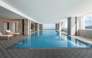 a large swimming pool in a building with a view at Crowne Plaza Xiamen Jimei Seaview, an IHG Hotel-Free Mini Bar in Xiamen