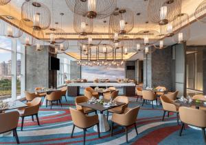 um restaurante com mesas e cadeiras e um bar em Crowne Plaza Xiamen Jimei Seaview, an IHG Hotel-Free Mini Bar em Xiamen