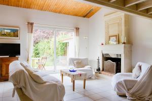 ein Wohnzimmer mit weißen Möbeln und einem Kamin in der Unterkunft Charmante maison au coeur de Saint Martin in Saint-Martin-de-Ré