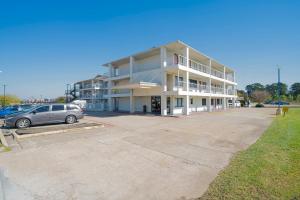 a building with a car parked in a parking lot at OYO Hotel Houston Humble IAH Airport HWY 59 in Humble