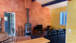 Una sala de estar con un sofá y una chimenea. en Le Soleil du Ventoux, en Entrechaux