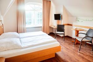 a bedroom with a bed and a desk and chairs at Dünen Stuuv in Böhl
