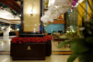 a lobby with red flowers and a restaurant at Town in Town Hotel Bangkok - SHA Plus in Bangkok