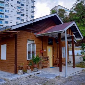 a small wooden house with a roof at The Rustique Guest House in Tanah Rata