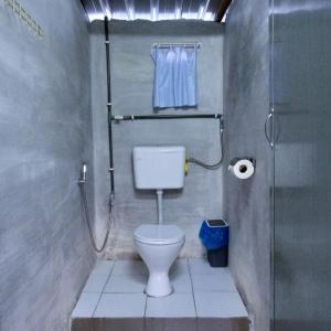 a small bathroom with a toilet and a shower at The Rustique Guest House in Tanah Rata