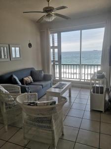 a living room with a couch and a view of the ocean at 21 Camarque in Umdloti