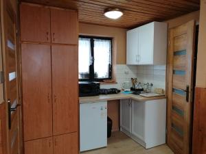 a kitchen with wooden cabinets and a white refrigerator at Privát Zvonček in Terchová