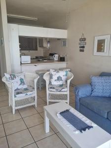 a living room with a couch and chairs and a table at 21 Camarque in Umdloti