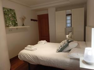 1 dormitorio con 1 cama con toallas en LOA GETARIA, en Getaria