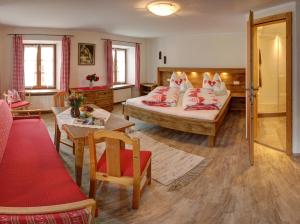 1 dormitorio con 1 cama, mesa y sillas en Biohof Wallnerhof - Chiemgau Karte, en Inzell