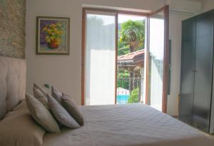 a bedroom with a large white bed with pillows at Villa Michelangelo - WelcHome in Cannobio