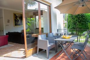 a patio with a table and chairs and an umbrella at Villa Michelangelo - WelcHome in Cannobio