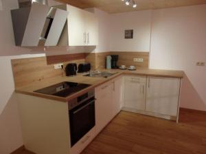 a kitchen with a sink and a stove at Ferienwohnungen Schwöblehen in Schönau am Königssee