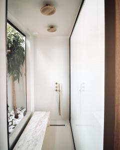 un pasillo con una puerta que conduce a un baño en Avgoustos Suites Naxos, en Naxos Chora