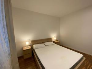 una camera da letto con un letto bianco con due luci sopra di EM home01 a Cattolica