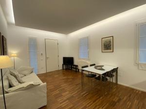 sala de estar blanca con mesa y sofá en EM home01 en Cattolica