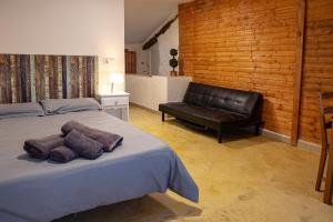 a bedroom with a bed and a leather couch at Fortress Jacuzzi Suites in Xàtiva