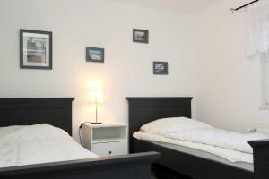 - une chambre avec 2 lits et une lampe sur le mur dans l'établissement Madleen, à Wieck