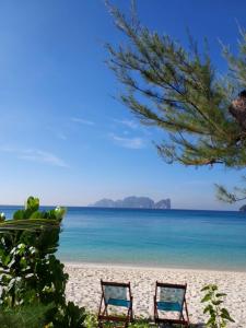 two chairs on a beach with the ocean at Paradise Pearl Bungalows in Phi Phi Don