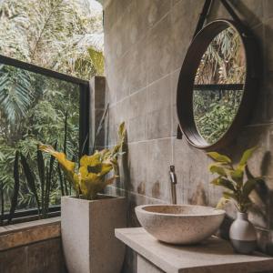 bagno con lavandino e specchio di Villa Kamar Tamu Selomartani a Sleman