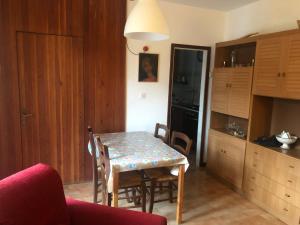 a kitchen with a table and chairs and a table and a room at Gli Abeti in Abetone