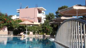 ein Pool mit Sonnenschirmen und ein Hotel in der Unterkunft Panorama Studios in Faliraki