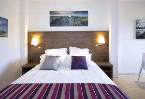 um quarto com uma grande cama branca e 2 almofadas em Lecques em Saint-Cyr-sur-Mer