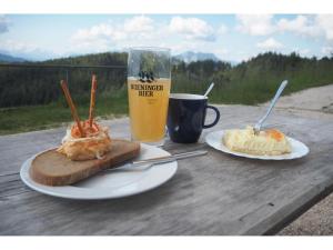 a table with two plates of food and a glass of beer at Ferienhaus Endrös - Chiemgau Karte in Inzell