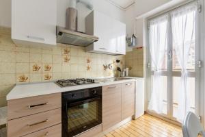a kitchen with white cabinets and a stove top oven at Bonola M1 Bright & Functional Flat in Milan