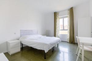 a white bedroom with a bed and a window at Bonola M1 Bright & Functional Flat in Milan