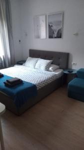 a bedroom with a bed and a blue ottoman at Apartments Simple Teslina in Zagreb