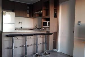 a kitchen with a counter and stools in it at Espectacular atardecer porteño-Viña in Viña del Mar