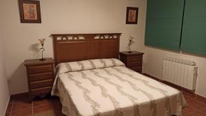 a bedroom with a bed and two night stands at Casa Rural los Portalillos II in Navatalgordo