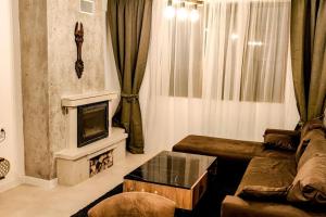 a living room with a couch and a fireplace at Луксозен Апартамент Мечи Чал - Апартхотел Манастира 2 in Pamporovo +22 photos