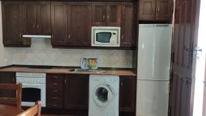 eine Küche mit einem weißen Kühlschrank und einer Waschmaschine in der Unterkunft Casa Rural El Molino II in San Bartolomé de Pinares