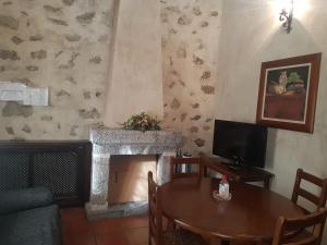 ein Wohnzimmer mit einem Tisch und einem Kamin in der Unterkunft Casa Rural El Molino II in San Bartolomé de Pinares