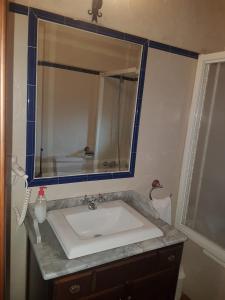 ein Badezimmer mit einem Waschbecken und einem großen Spiegel in der Unterkunft Casa Rural El Molino II in San Bartolomé de Pinares